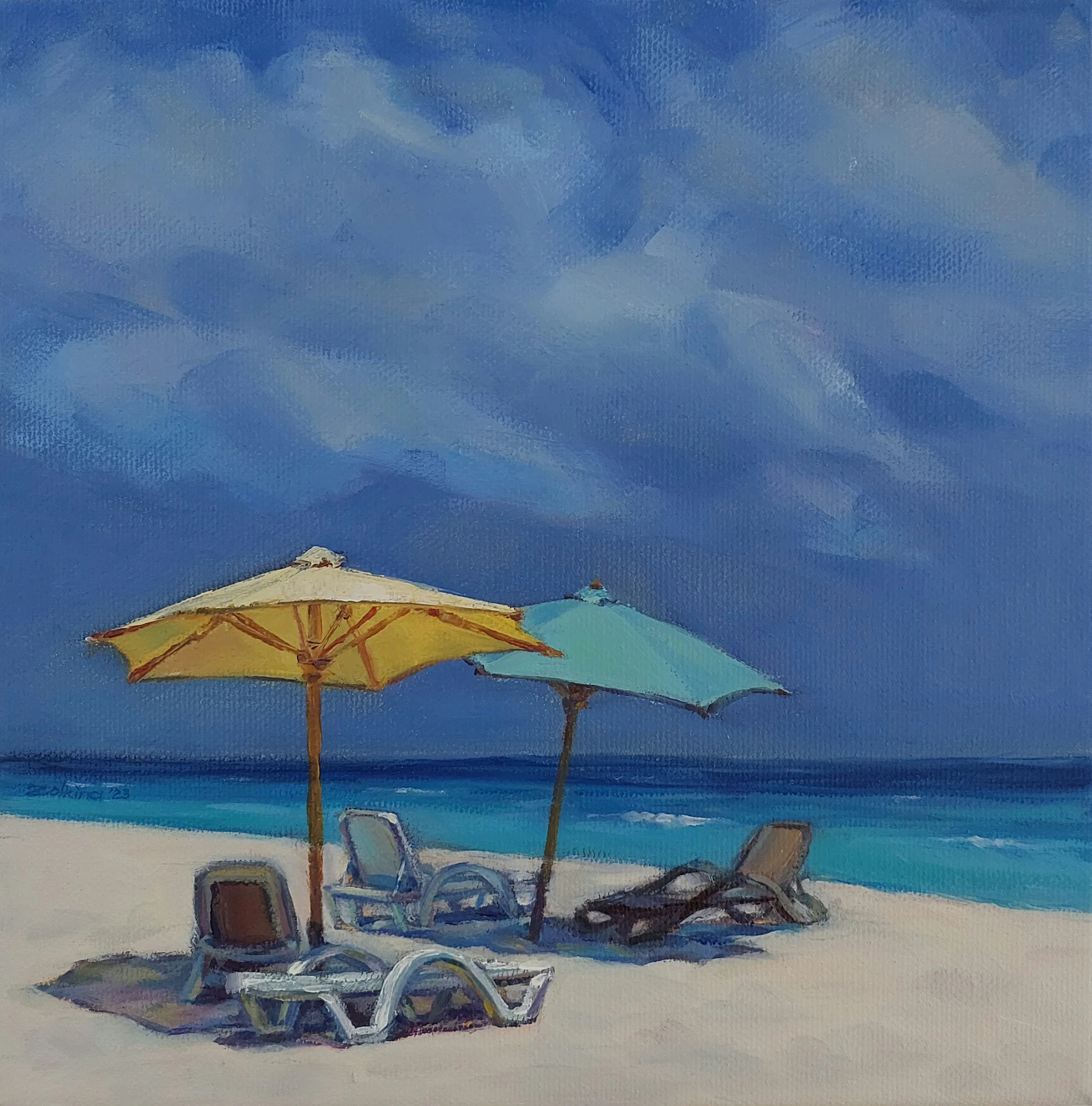 Yellow and turquoise beach umbrellas over sun loungers on white sand